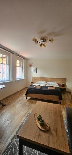 a bedroom with a bed and a coffee table at Apartament 5- Bliżej Zdroju in Polanica-Zdrój