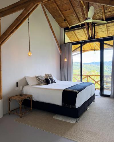 a bedroom with a large bed in a room with windows at Selva Serena in Anapoima