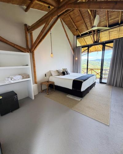 a bedroom with a bed in a room with windows at Selva Serena in Anapoima