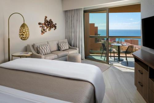 a bedroom with a bed and a couch and a balcony at The Westin Los Cabos Resort Villas in San José del Cabo