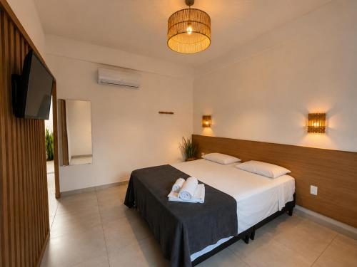 a bedroom with a bed with two towels on it at Villa Vinci Flat in São Miguel do Gostoso