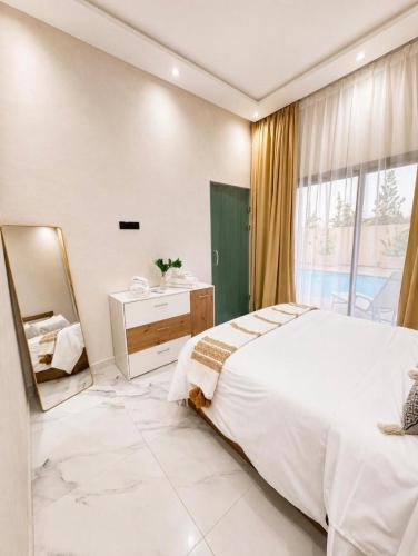 a bedroom with a large bed and a mirror at Villa Oumnass, Marrakech in Oumnas
