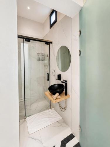 a bathroom with a glass shower with a sink at Villa Oumnass, Marrakech in Oumnas