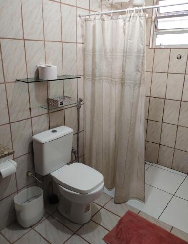 a bathroom with a toilet and a shower curtain at Chácara Paraíso do Mar - Araçagi in São José de Ribamar