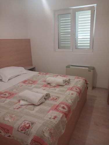 a bedroom with a bed with two towels on it at Apartments Maja in Hvar