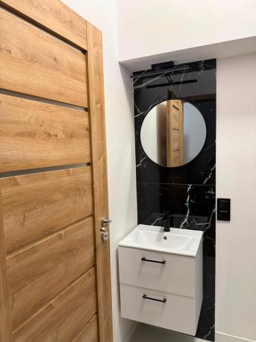 a bathroom with a sink and a mirror at Leśna Przystań in Pojezierze