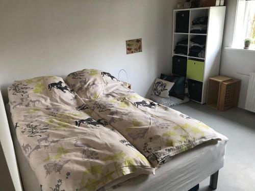 a bed with a comforter and pillows in a bedroom at Central apartment in Vestmanna in Vestmanna
