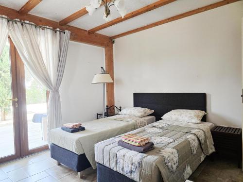 a bedroom with two beds and a large window at Pizzica Agriturismo in Metaponto