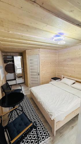 a bedroom with a bed and a chair in it at Едем 2 in Verkhovyna