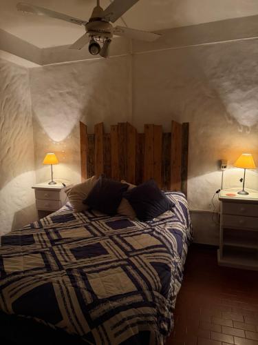 a bedroom with a bed with two night stands and two lamps at CASA JUNTO AL RIO in Paraná