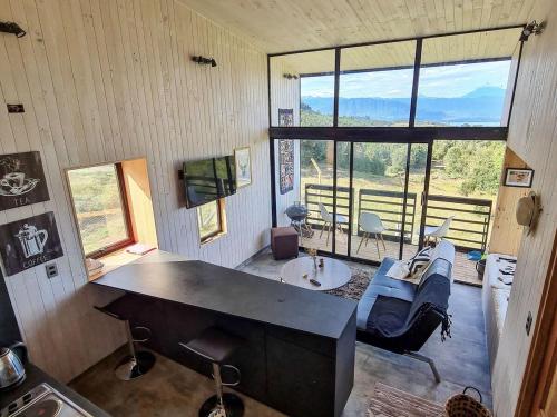 a living room with a couch and a table at Spectacular tiny house in an unforgettable setting in Ñilque
