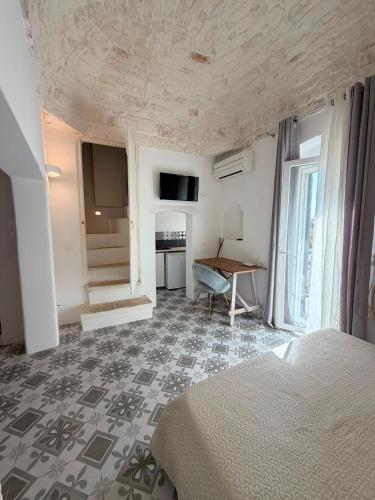 a bedroom with a bed and a table in a room at Casa Ulivo in Ostuni