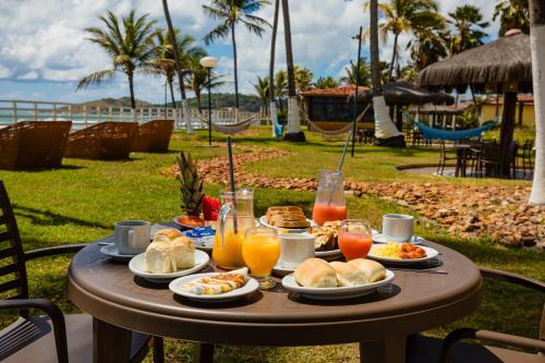 a table with breakfast foods and drinks on it at El Aram Beach Cabo - All Inclusive in Cabo de Santo Agostinho