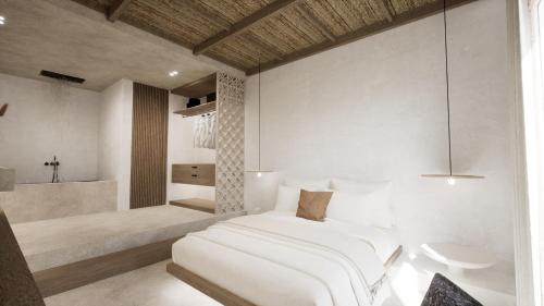 a bedroom with a white bed and a bathroom at Malie Suites in Mikri Vigla
