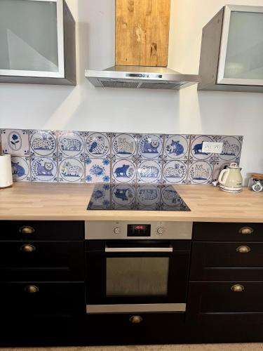 a kitchen with blue and white tiles on the wall at Le clos Ghisline in Madré