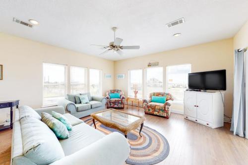 a living room with a couch and a tv at Charming ocean-view gem with a pool deck washer dryer & central AC in St. George Island