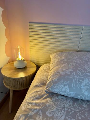 a bed with a lamp on a table next to a bed at Le clos Ghisline in Madré