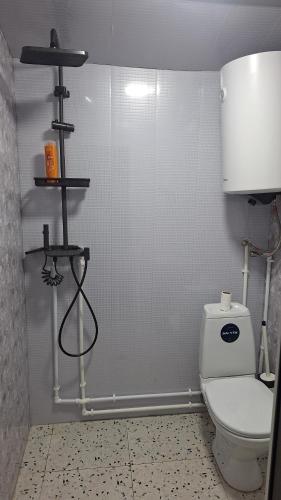 a bathroom with a toilet and a white tiled wall at Sarag in Ushguli