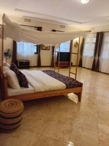 a bedroom with a canopy bed in a room at Kilimanjaro pazuri summit villas 1 in Msaranga