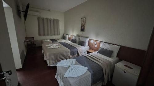 ein Hotelzimmer mit drei Betten in einem Zimmer in der Unterkunft Hotel Rafeli in Boituva