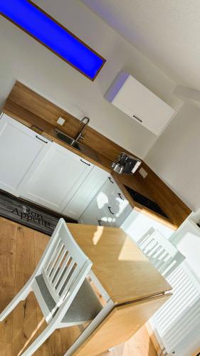 a kitchen with a wooden table and a white chair at Ferienwohnung Hortwald am Schaumberg in Tholey