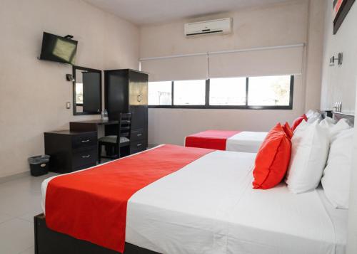 a bedroom with two beds with red and white pillows at Hotel Madrid in Tuxtla Gutiérrez