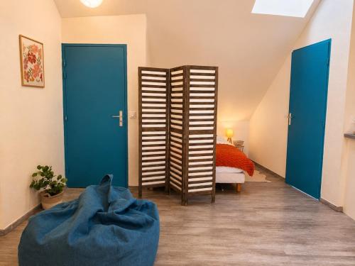 a room with blue doors and a room with a bed at Le Nid Dolois in Dole