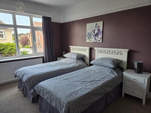 a bedroom with two beds and a window at Flown The Nest in Bridlington