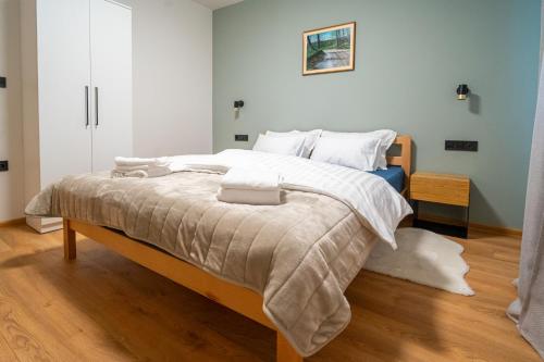 a bedroom with a large bed with white sheets at Kuća za odmor Vrata Papuka in Pakrac