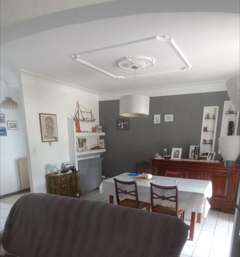 a living room with a table and chairs and a dining room at Maison tarnos in Tarnos