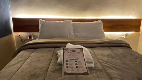 a bed with a sign sitting on top of it at Ninho do Vale - Centro Conservatória in Conservatória