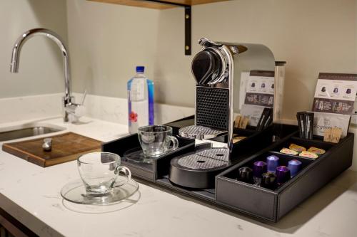 a kitchen counter with a drying rack on a sink at Archer Hotel Seattle/Redmond in Redmond