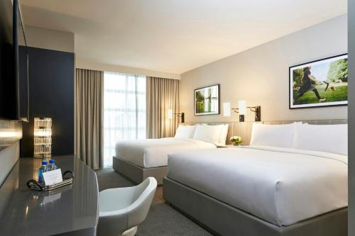 a hotel room with two beds and a desk at Archer Hotel Seattle/Redmond in Redmond