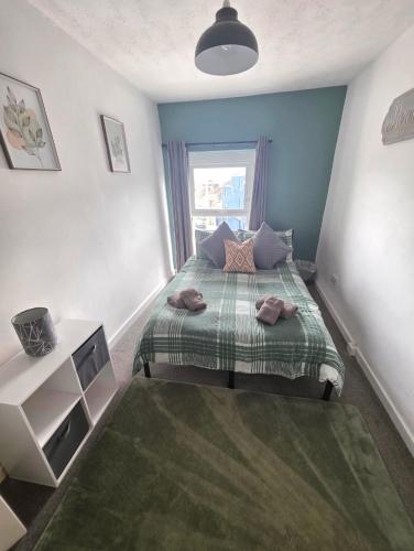 a small bedroom with a bed with a green blanket at Horizon Hideaway in Swansea