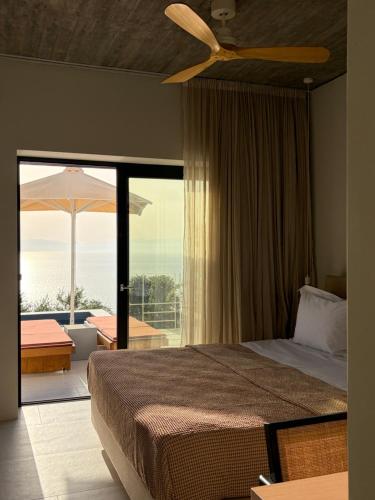 a bedroom with a bed with a ceiling fan and a balcony at KITO suites in Kitriaí