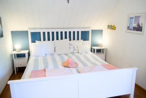 a large white bed with a pink hat on it at Sabines Sjöstuga in Bjärtrå