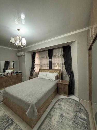 a bedroom with a large bed and a chandelier at Madigul in Andijan