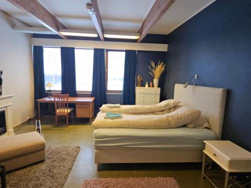 a bedroom with a bed and a table in a room at Solheim Guesthouse Andøy in Dverberg