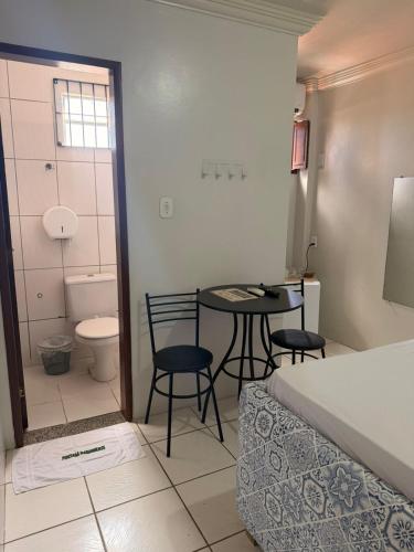 a bathroom with a table and chairs and a toilet at Hospedaria Maranhense in São Luís