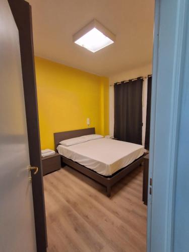 a bedroom with a bed and a yellow wall at Il Codibugnolo-casa vacanze Arezzo in Arezzo