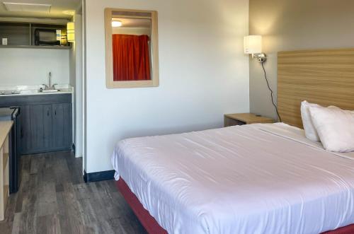 a hotel room with a bed and a kitchen at Studio 6 Fort Collins CO in Fort Collins