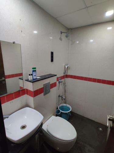 a bathroom with a toilet and a sink and a mirror at Sunleaf Palace in Pune