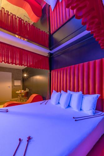 a bedroom with a large bed with red curtains at Dreams Motel (Adult Only) in Fortaleza