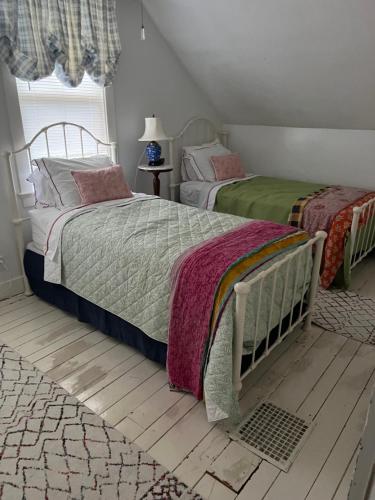 a bedroom with two beds and a rug at Westport Point Farmhouse in Westport Point