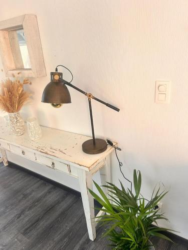 a desk with a lamp sitting on top of it at Maison Marthe in Sint-Truiden