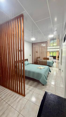 a bedroom with two beds with wooden dividers at Finch Nest Malecón in San Cristóbal
