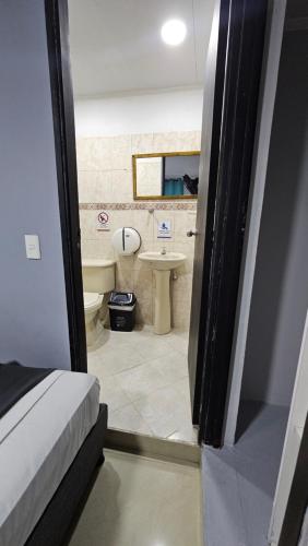 a small bathroom with a toilet and a sink at aparta hotel continental estadio in Medellín