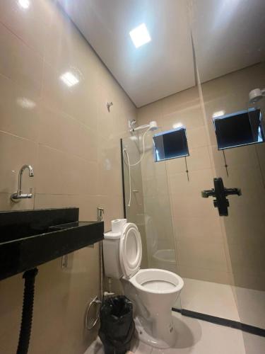 a bathroom with a toilet and a sink at Pousada Itaguaçu in Aparecida
