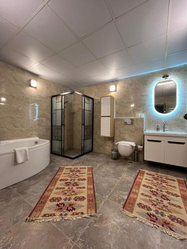 a bathroom with a tub and a toilet and a sink at ÖzkanHouse in Ürgüp