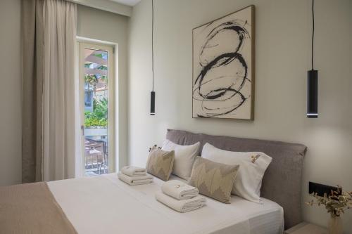 a white bedroom with a bed with towels on it at Argiri Apartments & Suites in Georgioupolis